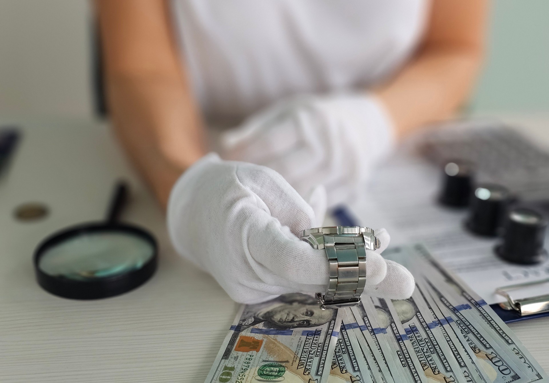 Expert appraiser inspecting a luxury watch next to stacks of cash